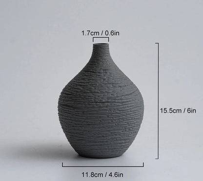 Dark grey textured vase with measurements on a light gray background