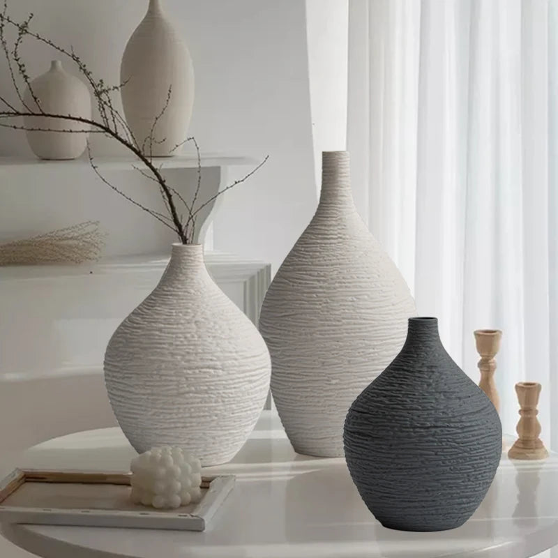 Three textured vases on a table with a neutral background