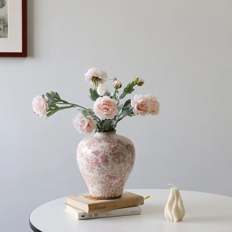 Decorative vase with flowers on a table against a plain wall