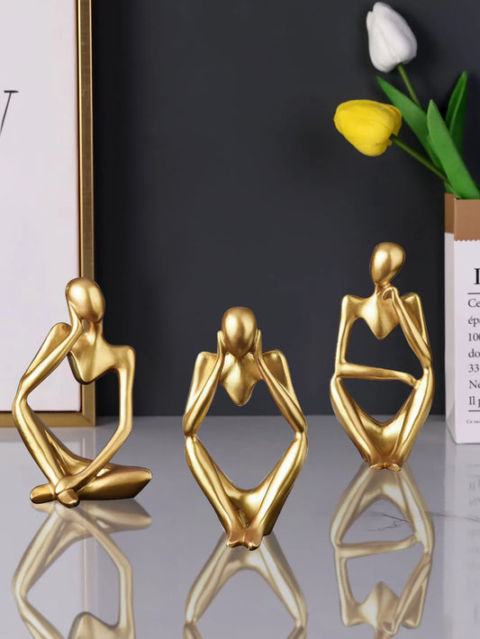 Small golden sculptures on shelf decor